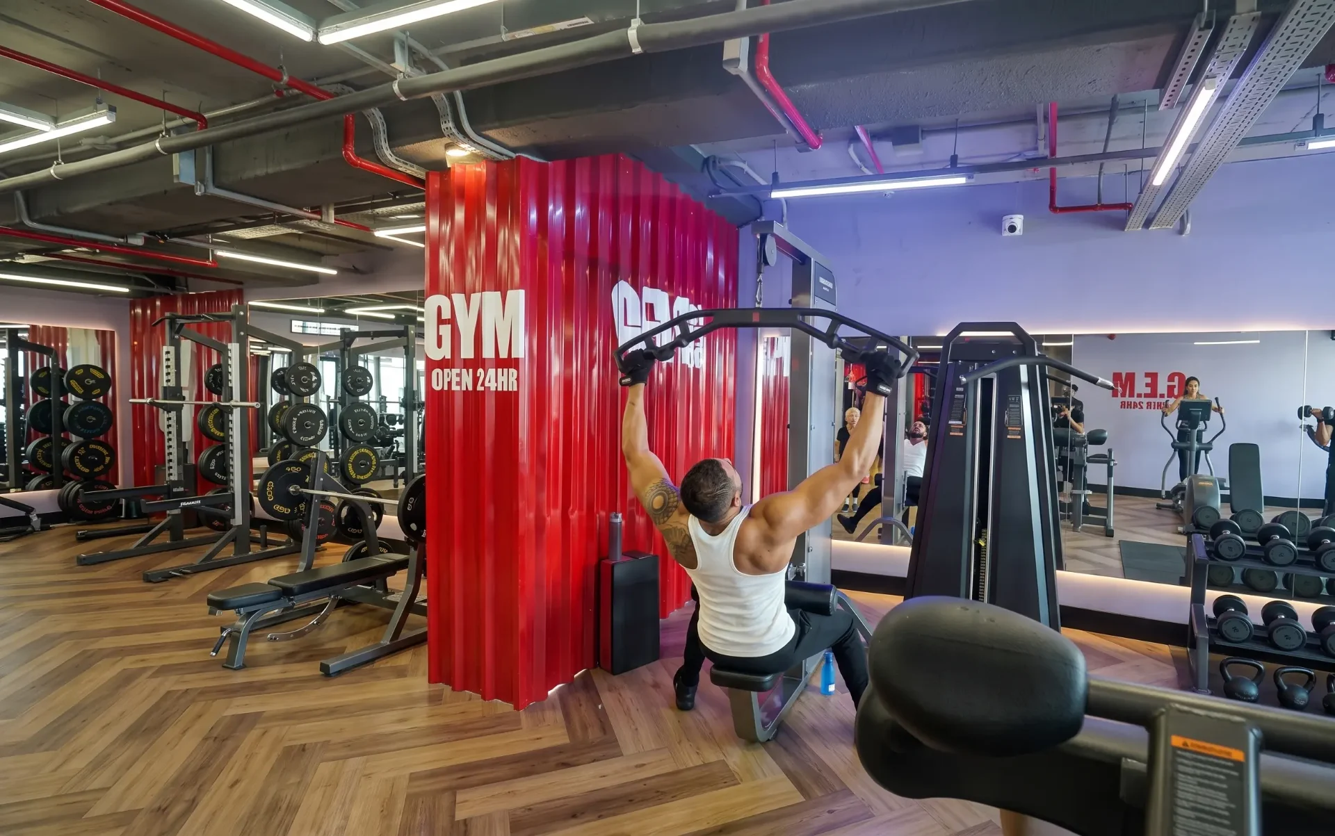 Homem treinando sozinho no pulley em academia 24h sem instrutor por perto
